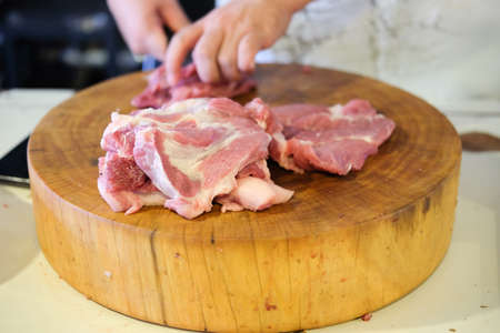 Raw pork and knife on a cutting board, close-up.の写真素材