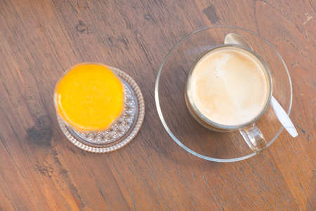 orange juice and hot coffee in glass, top view