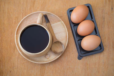 Breakfast set. Soft-boiled egg with hot coffee on wood tableの写真素材