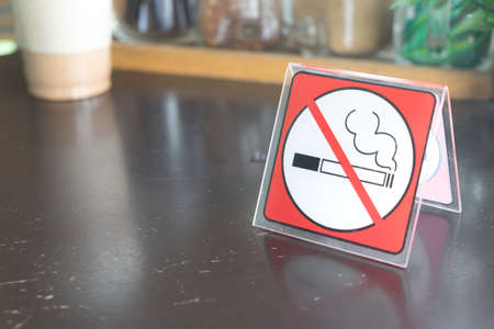 red tag no smoking sign displayed on a table in a cafeの写真素材