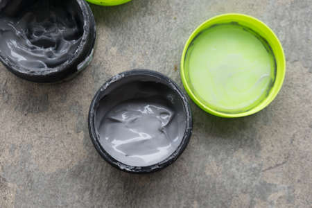 Open hair wax and clay in tubs, black clayの写真素材