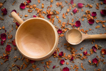 Wooden cup and spoon for hot drink, cup make from wooden on dry rose petalsの写真素材