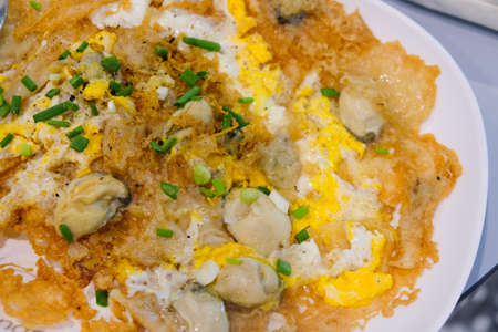 Fried crispy mussel omelet on white dishの写真素材