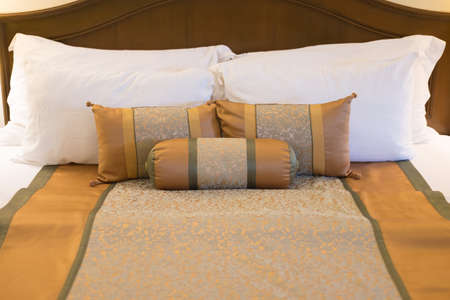 Hotel room setting with king sized bed decorated with pillows in hotel Thailandの写真素材