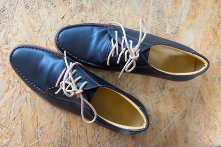 Pair of black classic modern shoes on wooden background