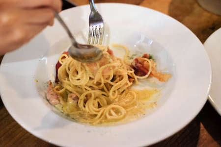 Close up top view eating seafood spaghetti in white dish with forks.の写真素材