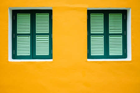 Lively style of architecture building wood windows with frame contrasting with vibrant yellow exterior wall of residential.の写真素材