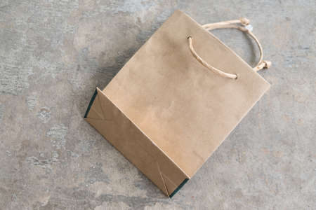 Recycled paper kraft shopping bag on concrete backgroundの写真素材