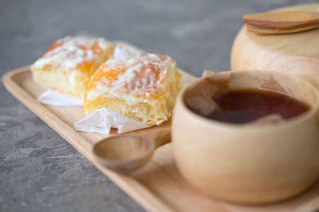 Dessert bread dusted with milk, sugar and butter on wood trayの写真素材
