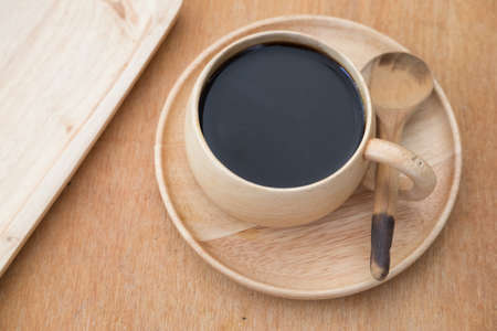 Cup of coffee in wood cup on wood tableの写真素材