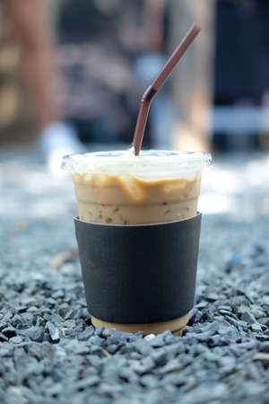 Cold coffee in plastic cup on stone