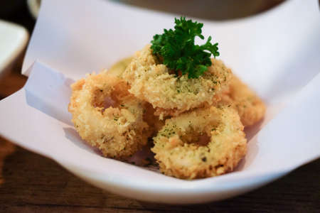 Fried onion rings crisp on white bowl