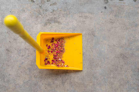 Yellow plastic dustpan with dirty dustの写真素材