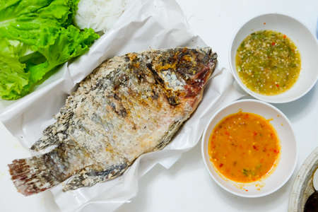 Tilapia fish grilled with Salt  and have Spicy Sauce, Thai foods style placedの写真素材