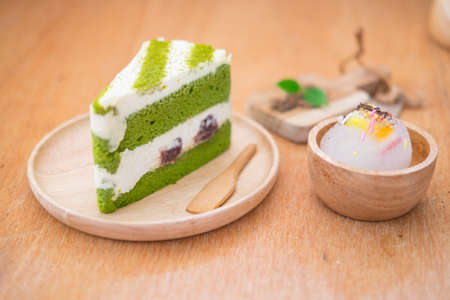 Cake matcha with red bean on wood dish in coffee shopの写真素材