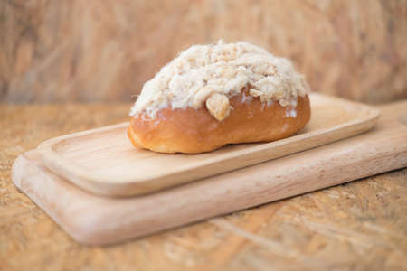 Homemade bun of bread with mayonnaise and pork floss on wood trayの写真素材