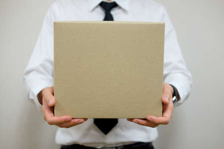 Young businessman carrying empty  brown paper box