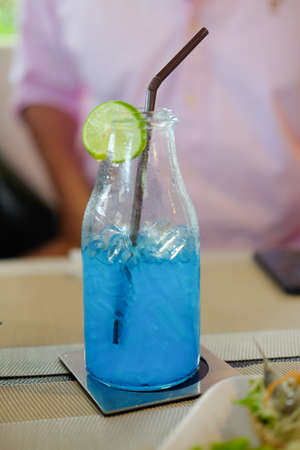 Blue cocktail refreshing summer drink with slice lime in glass jarの写真素材