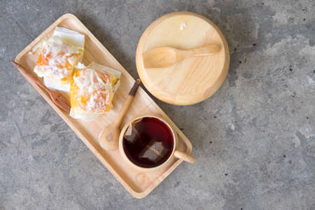 Butter bread sprinkled with sugar on wood tray with hot teaの写真素材