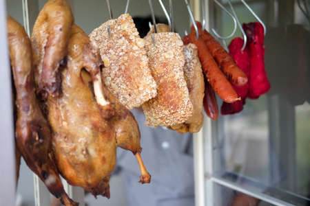 Boiled chicken, Chinese sausage and crispy pork hanging in the marketの写真素材