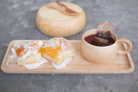 Fresh bread sprinkle with cream butter, sugar and hot teaの写真素材