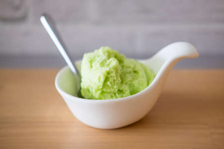 Lime ice cream in a white bowl close upの写真素材