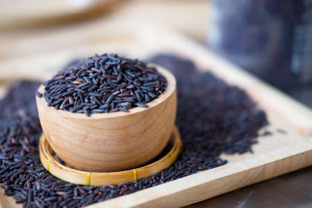 Riceberry in a wooden bowl on wooden backgroundの写真素材