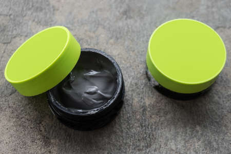 Open hair wax and clay in tubs, black clayの写真素材