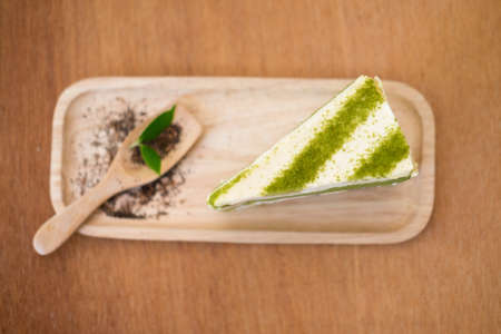 Green tea cake and spoon on wooden plateの写真素材