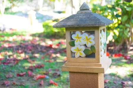 Plumeria flower carved stone on lamp postの写真素材