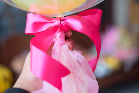 Man holding bunch of balloons, pink ribbon close upの写真素材