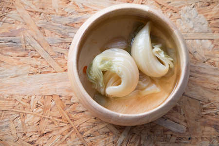 Pickled mustard green on wooden bowl, eat with rice porridgeの写真素材
