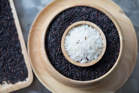 Jasmine rice in wooden bowl over Rice berry rice, Thai black jasmine rice (focus rice in wooden bowl)の写真素材