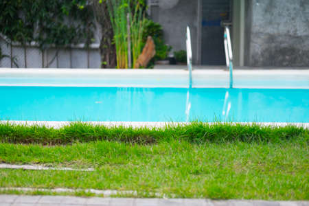 Blue swimming pool with green grassのeditorial素材