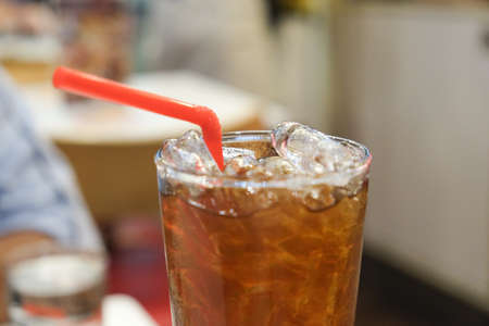 Soft Drink (cola) with ice and red straw, close upの写真素材