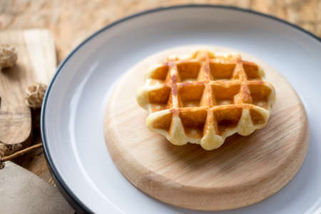 Tasty hot homemade waffles served on wooden plateの写真素材