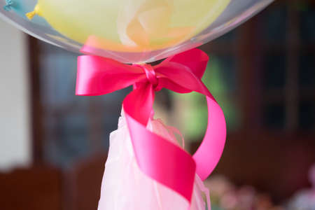Man holding bunch of balloons, pink ribbon close upの写真素材