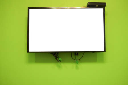 Blank LCD TV hanging at the green wall in homeの写真素材
