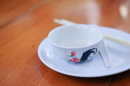 Traditional rooster painted ceramic bowl on wood table