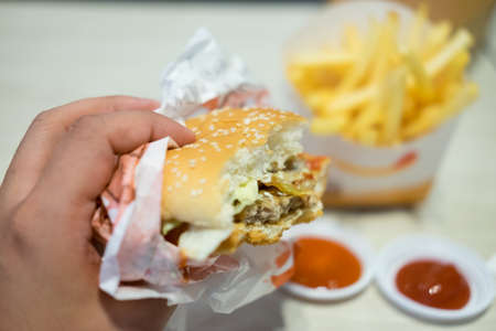 Eating hamburgers, bun with sesame on the fast food table backgroundの写真素材