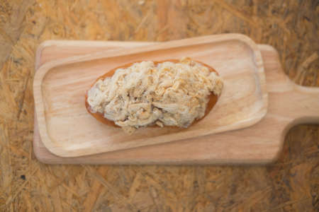 Homemade bun of bread with mayonnaise and pork floss on wood tray