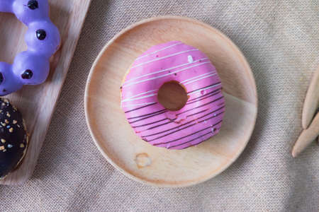 Assorted donuts with chocolate frosted pink glazed and sprinkles donutsの写真素材