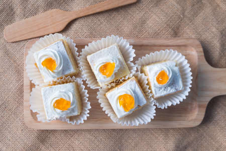 Vanilla butter cake topping cream on wooden trayの写真素材