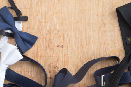 Set of man's accessories (bowtie and necktie) on wood table with copy space