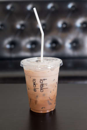 glass of iced mocha coffee with milk on wood table