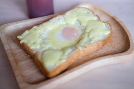 Breakfast food menu egg in a hole on wood plate