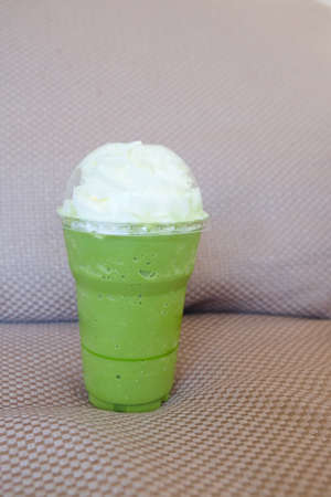 Iced matcha latte with coconut whipped creamの写真素材