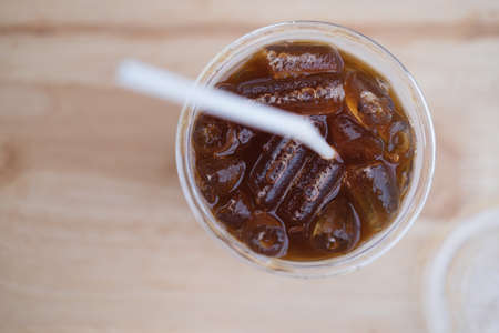 Closeup top view ice of americano or black coffee on wood tableの写真素材