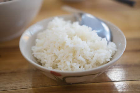 Cooked white rice in a bowl on wood tableの写真素材
