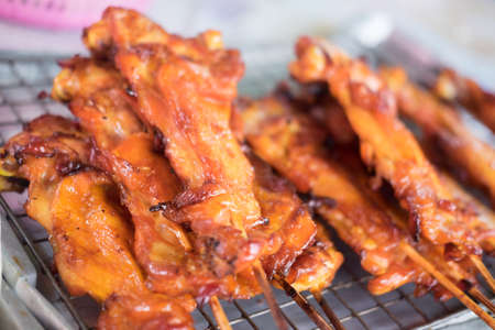 Grilling spiced chicken roasted chicken at street food vendor market Thai style foodの写真素材